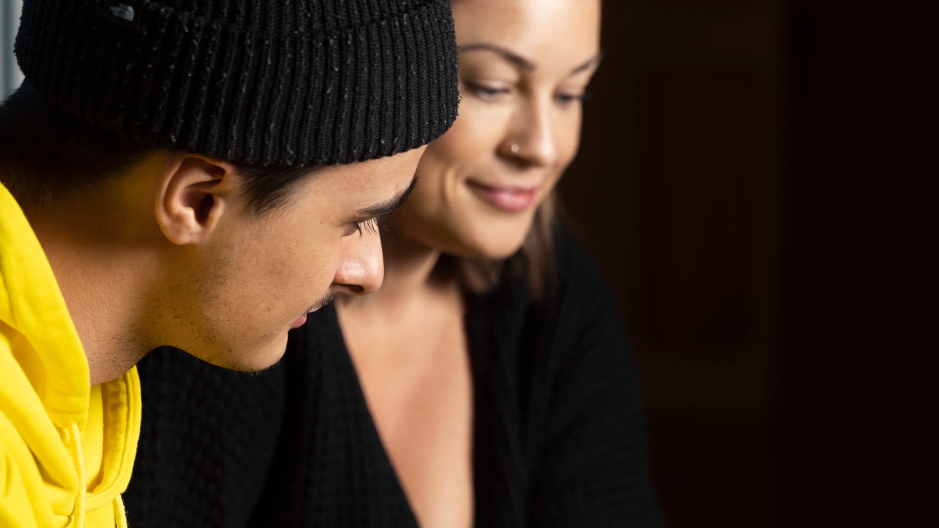 Närbild på en ung man och en ung kvinna som tittar på något som inte syns i bild.