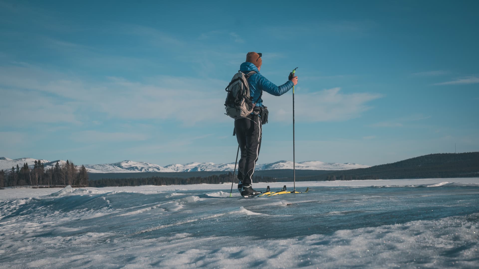 En skidåkare på våris med en fjällkedja i bakgrunden