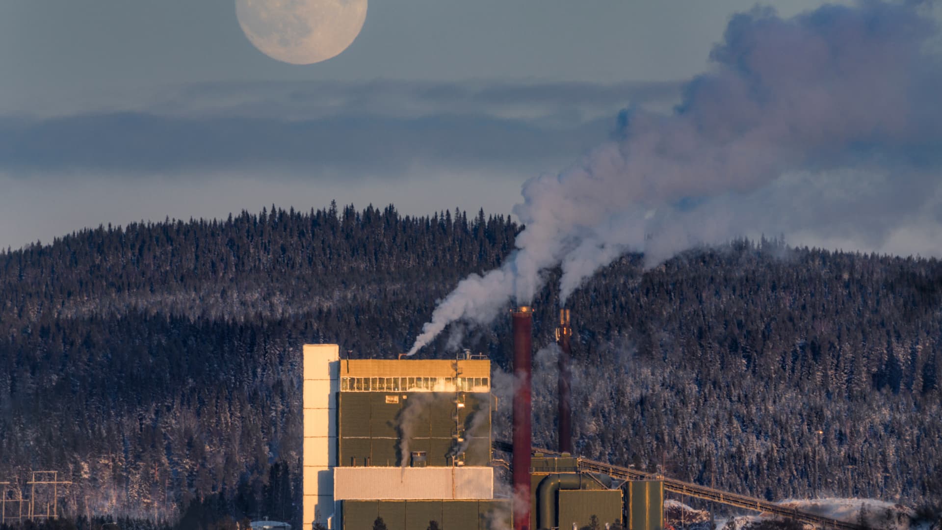 Fjärrvärmeverk under vintern med månen i bakgrunden
